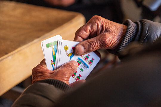 Italy, Sicily, Palermo Province, Santa Flavia. April 11, 2019. Man playing a card game in the fishing village of Santa Flavia.