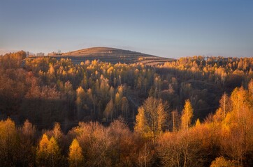 Fototapeta premium Autumn landscape with colorful forest on a hill.