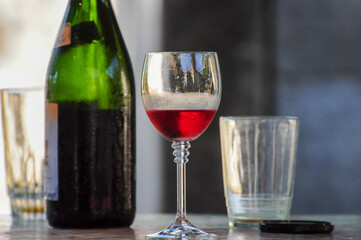 Red wine glass with empty glasses and bottle, creating an inviting ambiance
