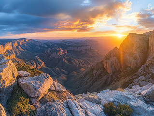 Naklejka premium Stunning sunset over a majestic mountain range with dramatic clouds and vivid colors, offering a breathtaking panoramic view.