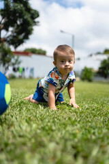 Photo of child with Down syndrome behind his toy ball
