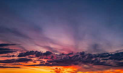 Sunset background. Dramatic sunset. Sky with clouds in sunset sky light background. Sunrise with clouds dawn sky. Calm sunset sky and sun through clouds over.