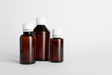 Medical bottles with medicine on white background, space for text