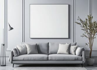 A gray sofa with pillows sits in front of a large blank canvas in a minimalist living room with a floor lamp and a potted plant.
