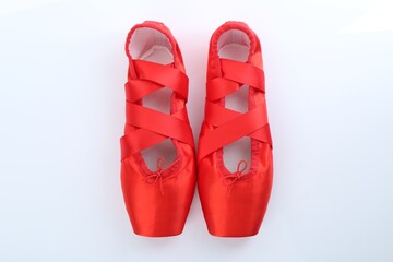 Pair of beautiful red pointe shoes on white background, top view