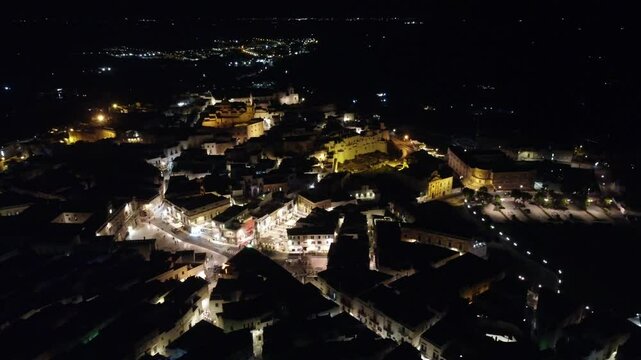 V&iacute;deo em vis&atilde;o a&eacute;rea noturna de Ostuni, It&aacute;lia, capturando a beleza da cidade iluminada com suas ruas estreitas e arquitetura hist&oacute;rica, destacando o charme mediterr&acirc;neo e a tranquilidade noturno