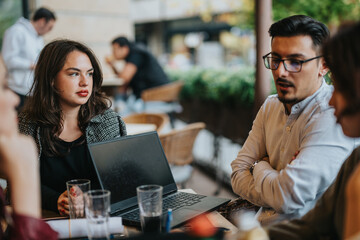 A group of business people having a focused discussion outdoors, emphasizing collaboration and teamwork. The setting provides a casual yet productive environment for brainstorming and idea exchange.