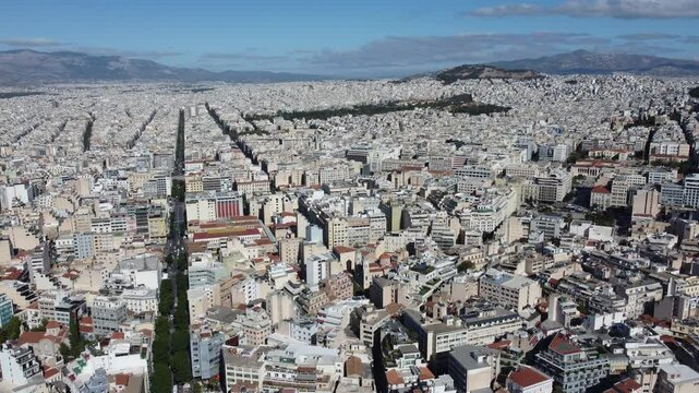 Pr&eacute;dios modernos no centro urbano de Atenas, Gr&eacute;cia, com sua mistura de arquitetura contempor&acirc;nea e hist&oacute;rica, destacando a vida urbana vibrante e o ambiente cosmopolita