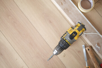 Using a Power Drill on a Wooden Floor for a Home Improvement Project and Renovation