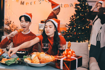 Group of young Asian man and women as friends having fun at a New Year's celebration, holding gift...