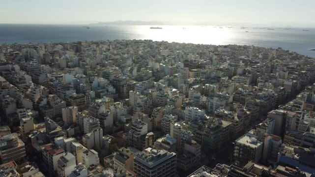 Vis&atilde;o a&eacute;rea do centro urbano de Atenas, Gr&eacute;cia, ao final do dia, com a luz dourada do p&ocirc;r do sol iluminando as ruas e a arquitetura hist&oacute;rica, criando uma atmosfera vibrante e &uacute;nica