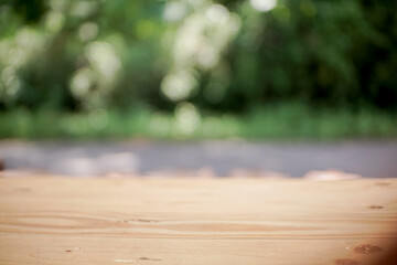 Selective focus. Wood end grain table with blur green forest background for product display montage or design