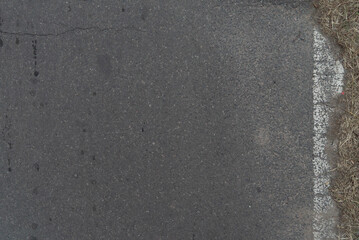 Asphalt road with barely visible white painted line in Ezeiza, Buenos Aires, Argentina.