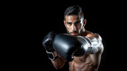 A Boxer Wearing Black Gloves Throws a Punch Against a Black Background