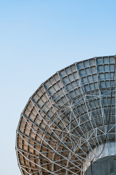 Radio telescope giant paraboloid surface in morning sunlight with blue sky background