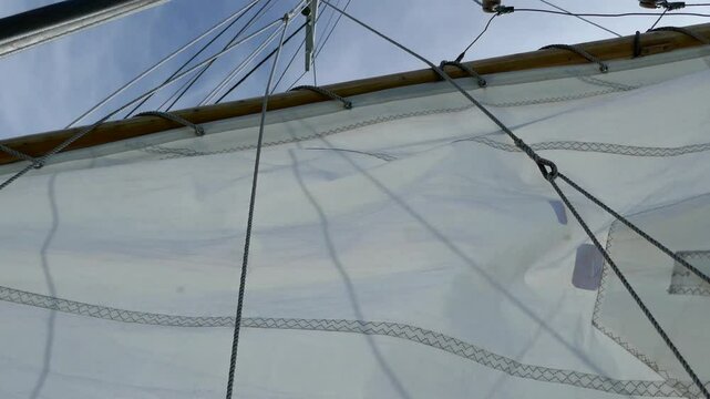 Sailboat sail waving in the wind then dropping the sail