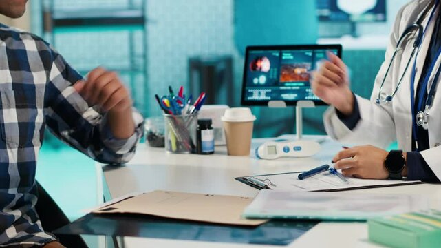 Expert using smartwatch to measure patient heart rate and heartbeat during a medical check up visit. Consultation involves pulse and blood pressure analysis at appointment in office. Camera A.