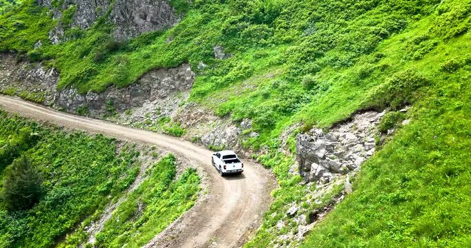 Car Tracking. Double cabin car driving on a driveway on a green background. Aerial tracking. A unique view. High quality image.