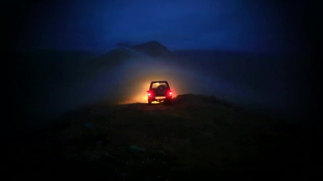 A car travelling at night at the summit.