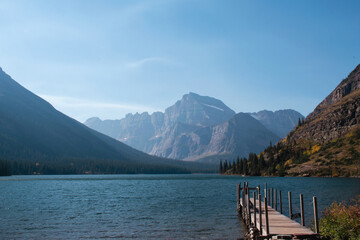 Swiftcurrent Lake reflects the pristine beauty of Glacier National Park, surrounded by towering peaks and dense forests.