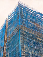 Construction in Progress: Building with Scaffolding and Blue Drapes