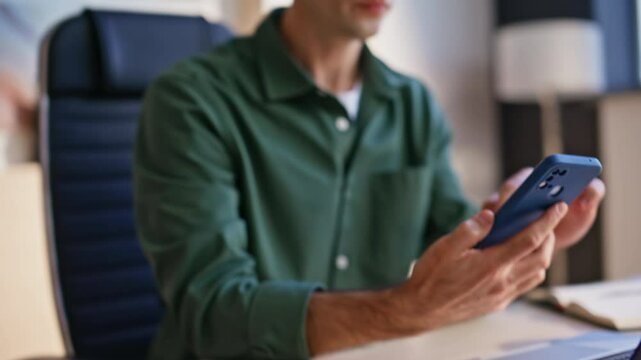 Businessman hand taking cellphone from desk receiving sms closeup. Worried man