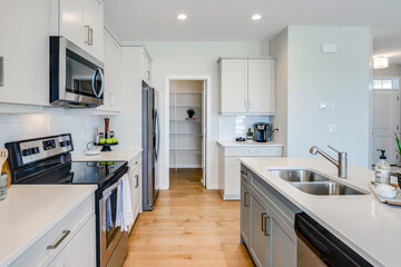 A kitchen with a white counter and stainless steel appliances