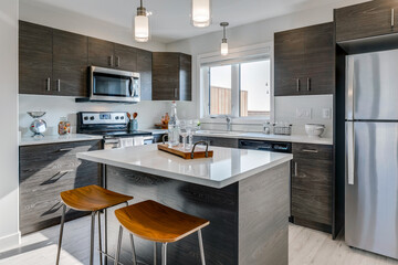 A kitchen with a white island and a silver refrigerator