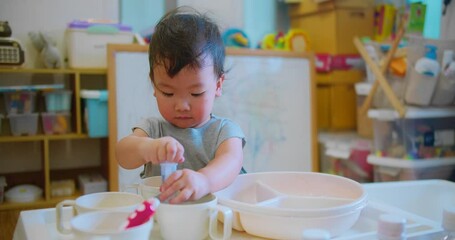 young child holding a syringe while engaging in imaginative play doing chemistry experiments science, explores and learns through play with educational toys environment. - Powered by Adobe