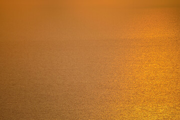 Water surface with sunlight sparkles golden background