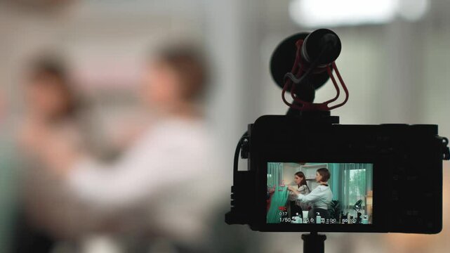Rear view behide camera screen display two women influencer shoot vlog video review clothes prim social media or blog. Girls with apparel studio lighting for live streaming marketing recording session