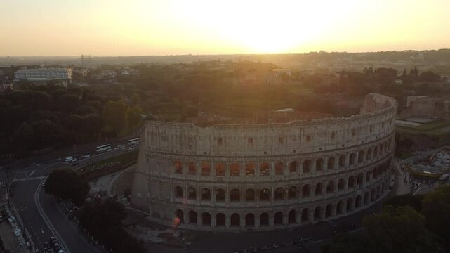 V&iacute;deo de um sobrevoo pelo Coliseu de Roma ao p&ocirc;r do sol, com luz dourada iluminando o anfiteatro hist&oacute;rico e destacando a beleza da arquitetura romana em um dia de c&eacute;u claro