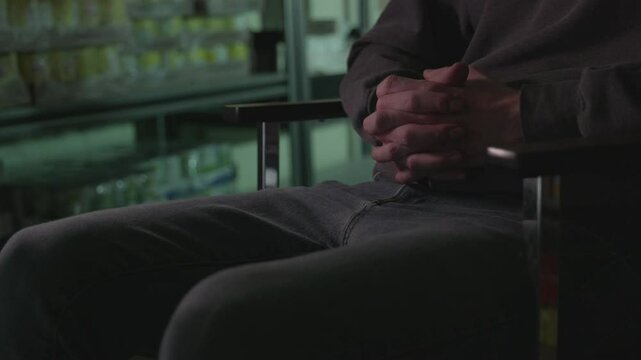 Low view of the legs and hands of an anonymous person.