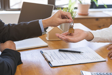 Close up agent giving a key to new owner or tenant, client after signed signature contract rental...