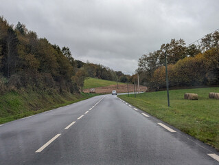 Fototapeta premium Countryside road in Dordogne France with autumn scenery and car