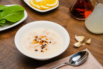 Tripe soup in a white bowl, garnished with vinegar and lemon. Turkish cuisine Soup, traditional healing soup made with tripe.