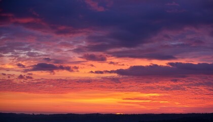 Fototapeta premium A mesmerizing sunset casts a warm glow on the landscape below