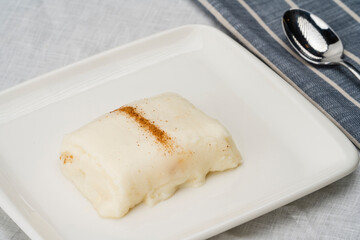 Chicken Breast Dessert garnished with cinnamon. Traditional Turkish dessert served with a spoon.