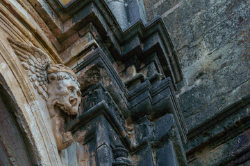 ronda,malaga,spain gargoyle on the facade of a stone church darkened by time