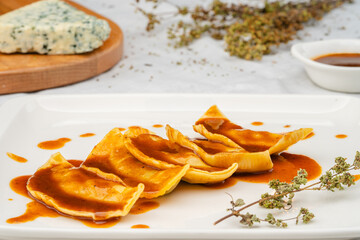 Italian Ravioli pasta. Handmade pasta served in a white pasta plate with a special sauce.