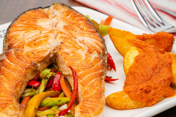 Grilled Salmon with vegetable salad and fried potato. Delicious Salmon.