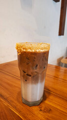 a mixture of espresso and steamed milk on a tall glass