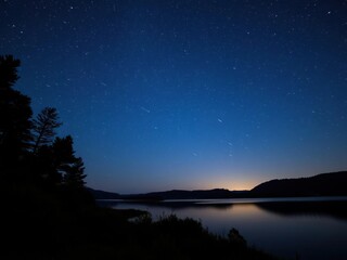 Naklejka premium Meteor shower in the night sky above a serene lake, meteor shower, starry night