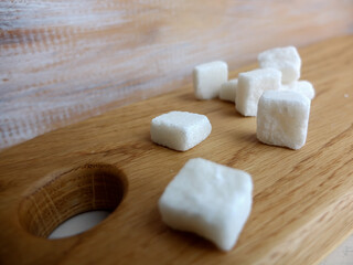 sugar cubes close up on wooden board