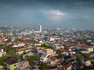 Panoramic views of Semarang's hillside neighborhoods under moody morning skies, showing the city's expansion towards the mountains with a mix of residential and commercial developments