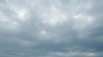 Obraz premium Overcast sky with soft white clouds scattered across a blue-gray background, weather conditions, misty landscape
