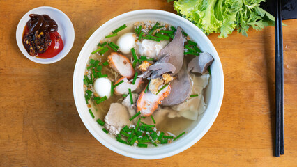 Egg noodles with pork wonton soup or pork dumplings soup and vegetable isolated. Chinese egg noodle topping slice roasted pork and wontons