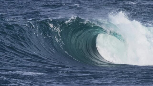 Angled side view of a hollow wave, foam ball erupting from the barrel in slow motion