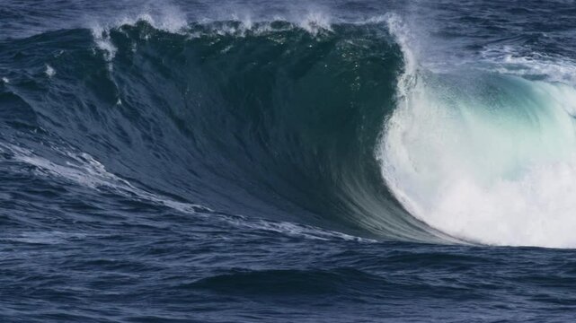 Angled side view of barreling wave, foam ball spitting out dramatically in slow motion