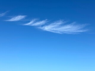 Cirrus white clouds in sunny blue sky 